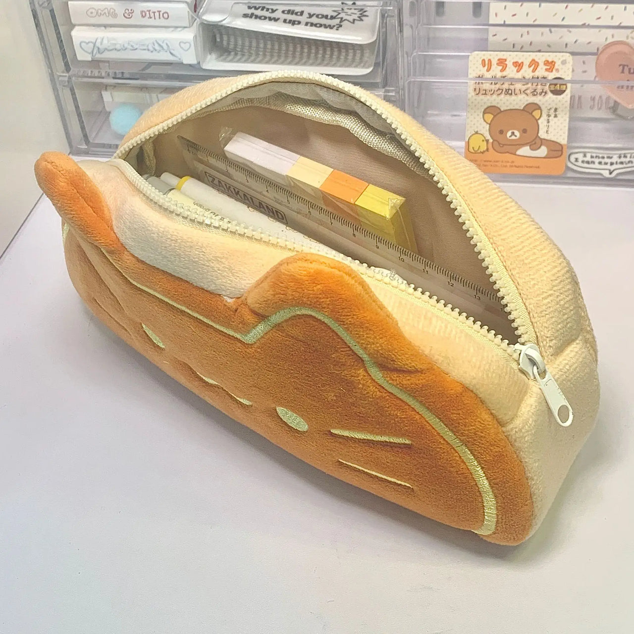 The Caramel Cat Plush Pencil Case by KittyNook Cat Co. unzips to hold pens, sticky notes, and plush school supplies.