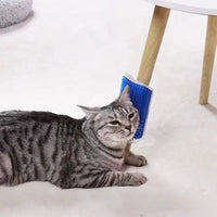 Thumbnail for A gray tabby cat rubs its cheek on KittyNook Cat Co.’s Ultimate Self-Cleaning Cat Brush attached to a table leg.