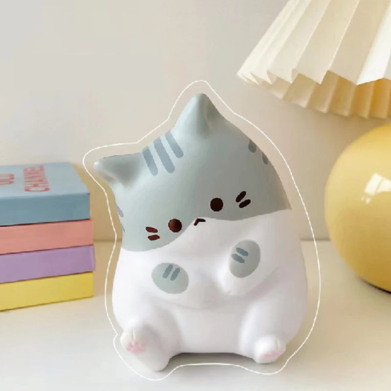 The KittyNook Cat Co. Cat Squeeze Ball is a cute gray and white squishy cat toy, perfect for stress relief.