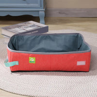 Thumbnail for The KittyNook Cat Co. Portable Cat Litter Box in red and gray rests on a rug near books and a blue cabinet.