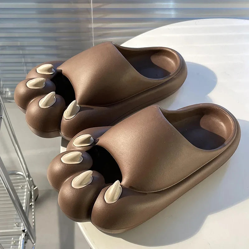 KittyNook Cat Co. Comfy Outdoor Cat Slippers with cute feline faces and white claws rest on a round white table.