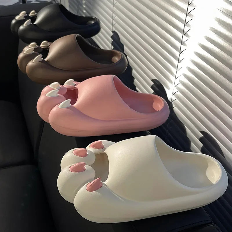 Four pairs of KittyNook Cat Co. Comfy Outdoor Cat Slippers are displayed on a black couch by a window.