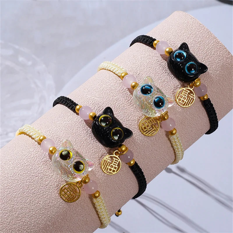 Four KittyNook Cat Co. Lucky Charm Bracelets for Good Fortune, ideal Pet Parent Gifts, displayed on a light stand.