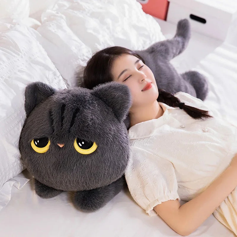 A woman rests on a bed, her head on a Plush Cat Pillow by KittyNook Cat Co.—a cozy, whimsical gift for cat lovers.