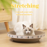 Thumbnail for A white cat lounges in the Oval Corrugated Cat Scratching Board by KittyNook Cat Co.—“Stretching. Unleash instincts.”.