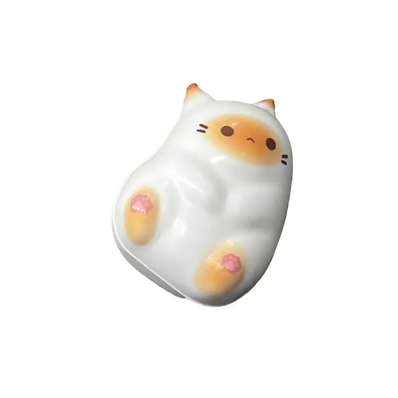 KittyNook Cat Co. Cat Squeeze Ball: a cute white squishy cat toy with orange ears and pink paw pads.