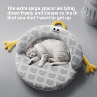 Thumbnail for A gray and white cat naps curled on KittyNook Cat Co.'s Ice Silk Cat Nest, a round cartoon-themed summer bed.