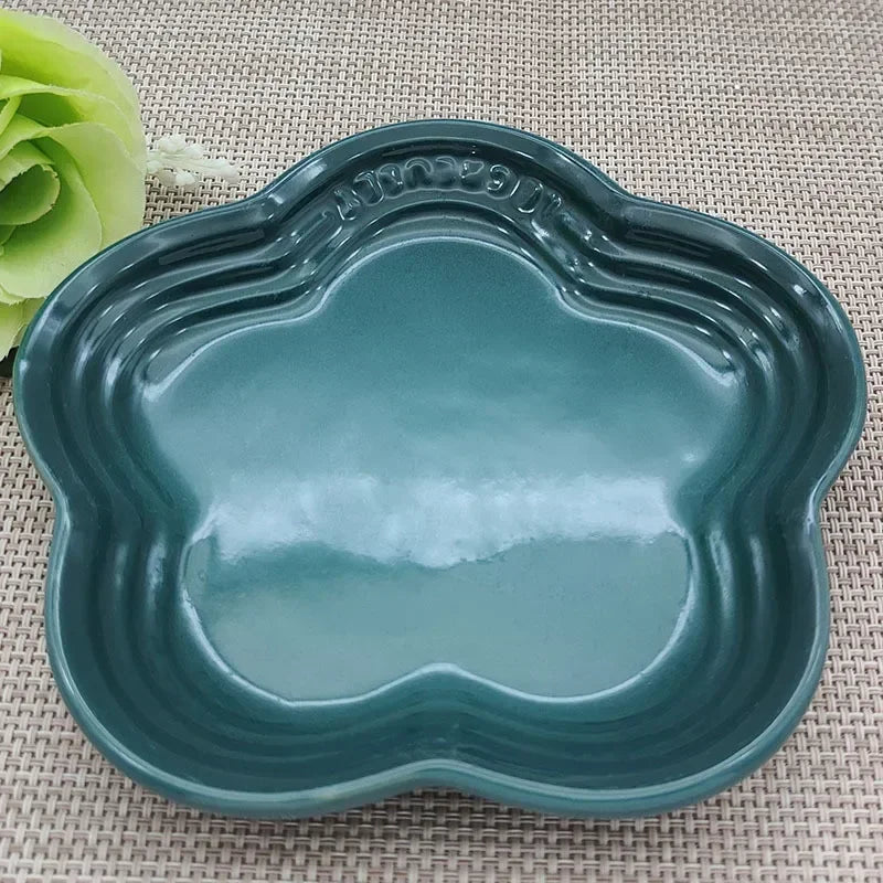 KittyNook Cat Co. Extra Wide Raised Flower Cat Bowl in teal on a woven mat, with a green faux flower in the corner.