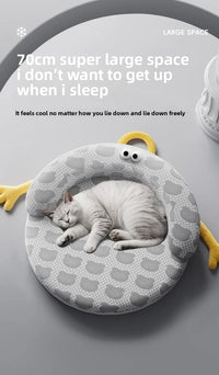 Thumbnail for A white cat curls up on a gray KittyNook Cat Co. Ice Silk Cat Nest with cartoon eyes and yellow arms.