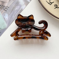 Thumbnail for KittyNook Cat Co. Cute Cat Hair Claw in brown tortoiseshell with bow tie, shown on white surface near a plate.