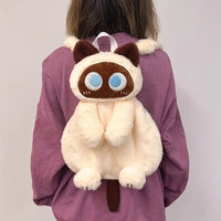Thumbnail for Person wears The Cute Big Eyes Plush Backpack by KittyNook Cat Co. over a mauve shirt; features blue eyes, brown ears, tail.