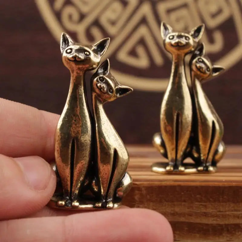 KittyNook Cat Co.’s Intertwined Loving Cats Brass Sculpture: two brass cats sit together, symbolizing love and unity.