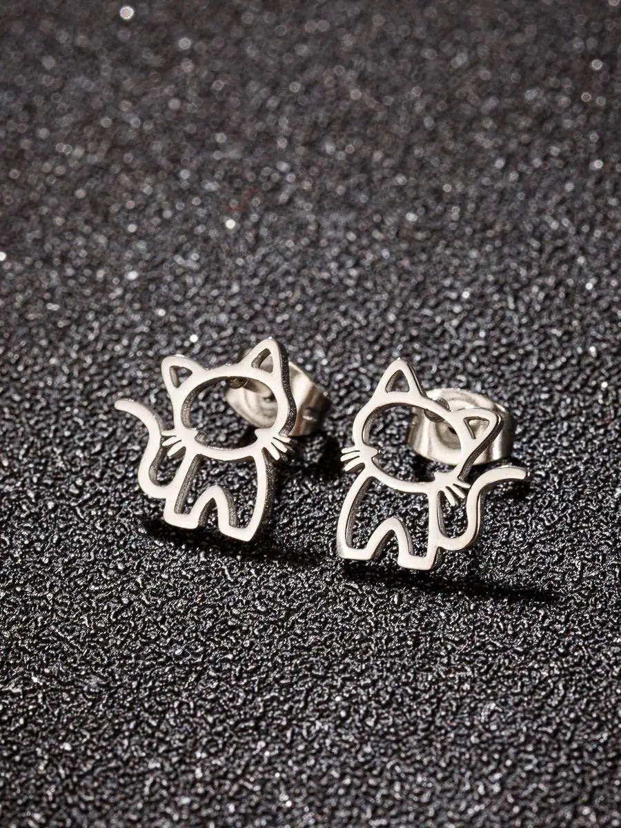 KittyShine Stainless Steel Ear Studs by KittyNook Cat Co.—cute cat-shaped accessories on a textured black surface.