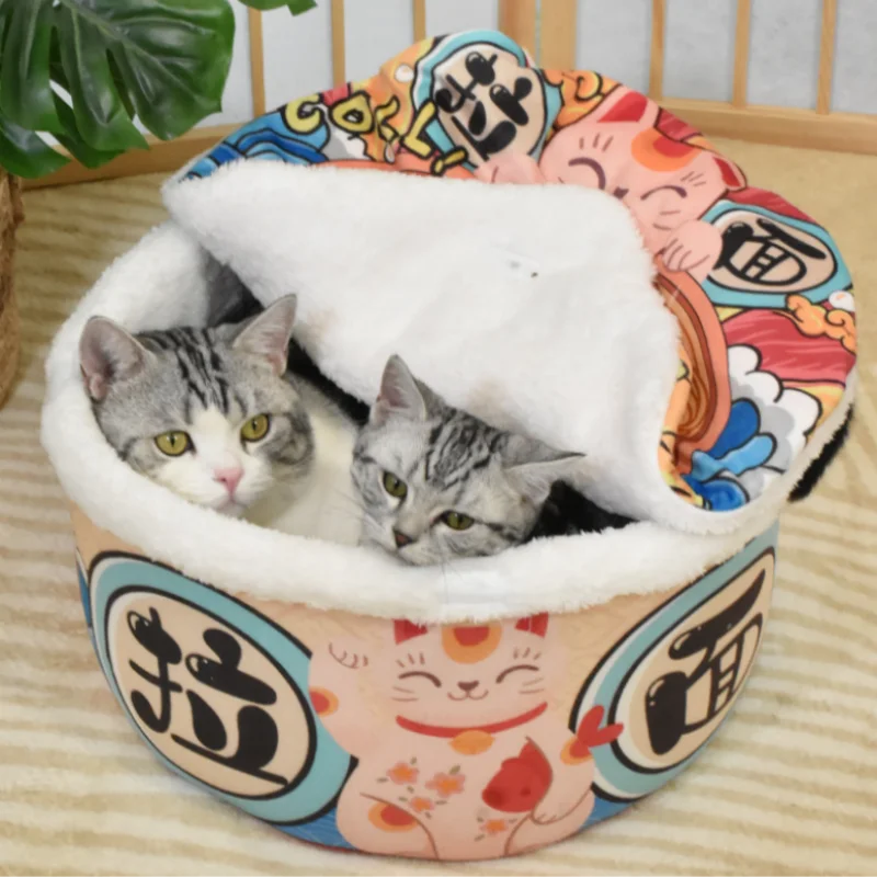 Two gray tabby cats snuggle in a KittyNook Cat Co. Giant Ramen Bowl Cat Bed with soft white lining and cute designs.