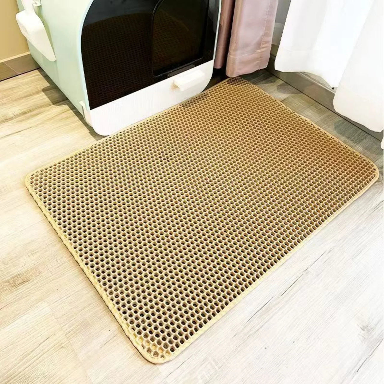 KittyNook Cat Co. Non-Slip Dual Layer Litter Trapper mat on wood floor by a litter box and white curtains.