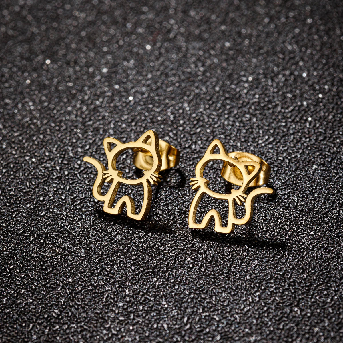 KittyShine Stainless Steel Ear Studs by KittyNook Cat Co., cute cat accessories on a textured black surface.