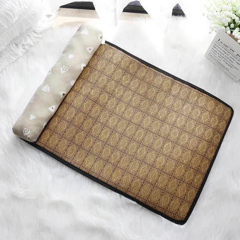 The KittyNook Cat Co. Natural Rattan Cat Sleeping Mat with beige pillow sits on a white fluffy surface near a window.