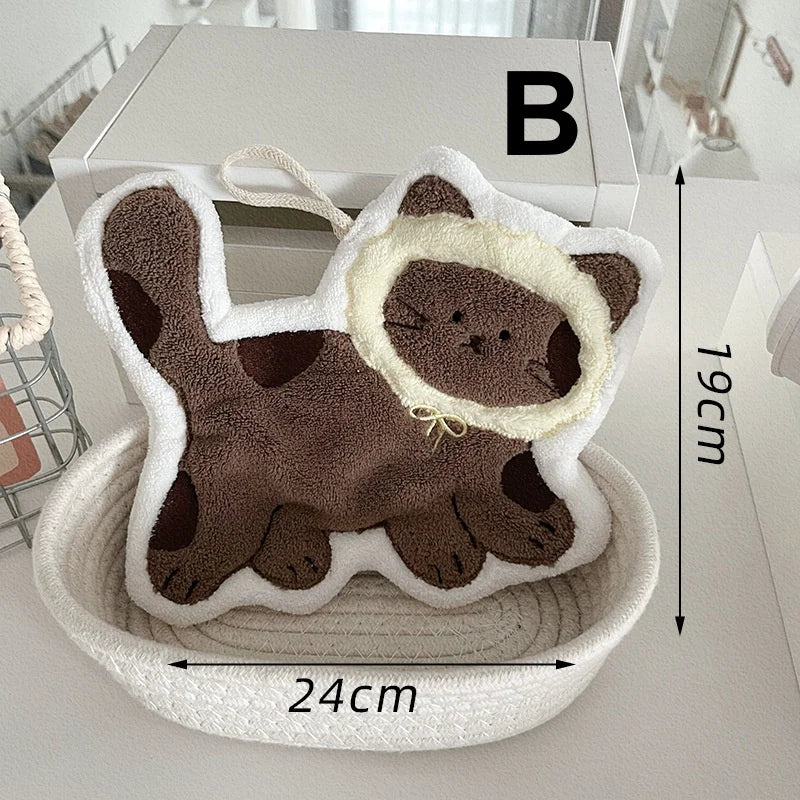 KittyNook Cat Co. Soft Cat Paw Hand Towel, plush, 24x19cm, cream mane, in white basket labeled "B".