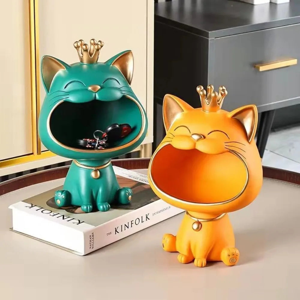 Two Creative Cat Key Boxes by KittyNook Cat Co.—one green, one orange—crown-topped, sit on a table.