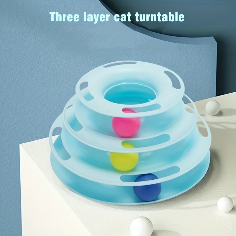 KittyNook Cat Co. 3-Layer Interactive Cat Toy Tower with balls, pictured on a white surface against a blue wall.