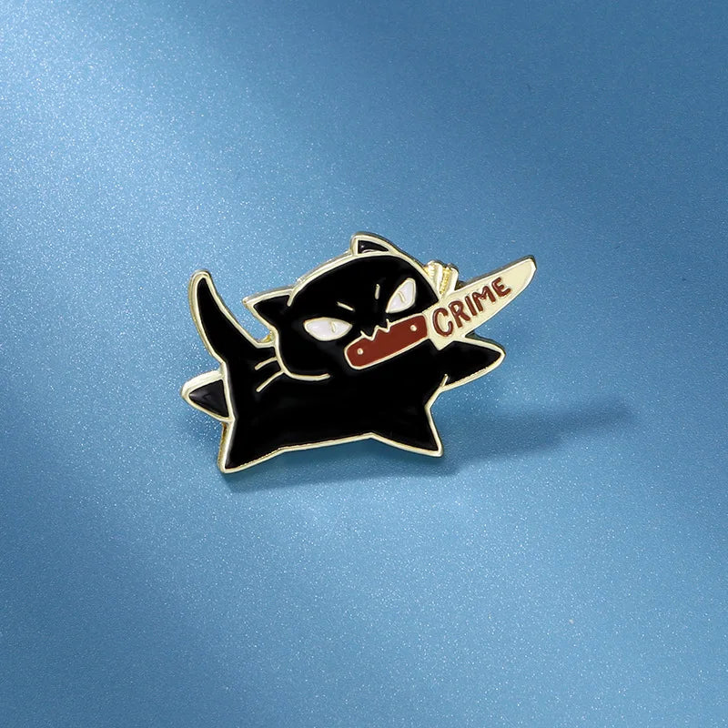 The Cute Black Cat Enamel Brooch by KittyNook Cat Co. features a cartoon cat with a "CRIME" knife on blue background.