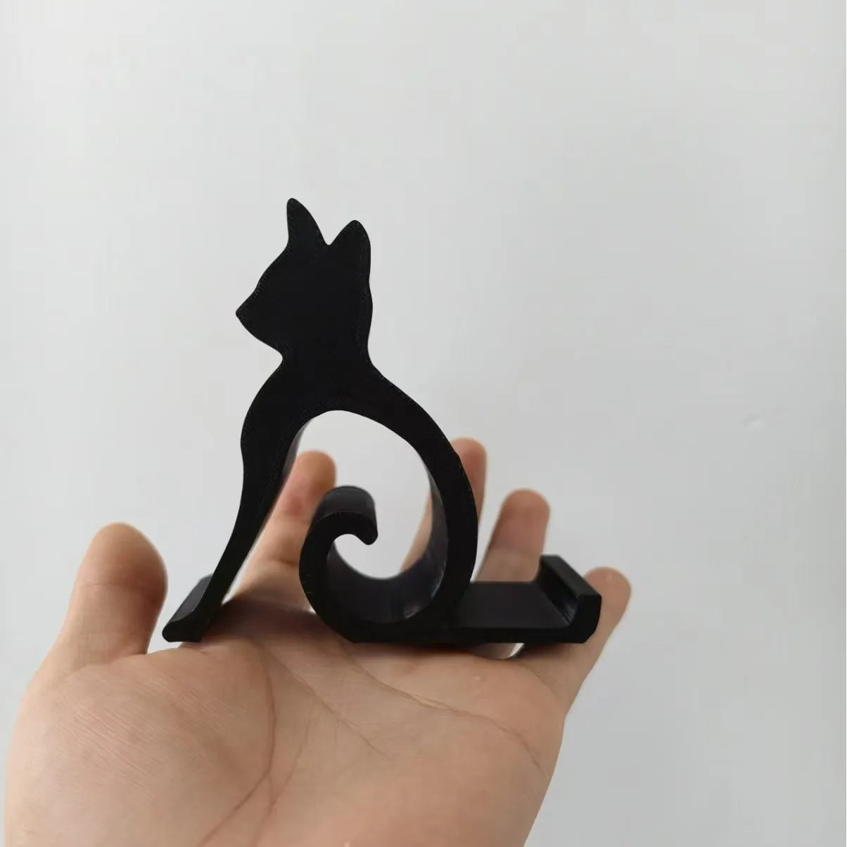 A hand holding a Cute Cat Phone Stand – Adjustable Mobile & Tablet Holder.