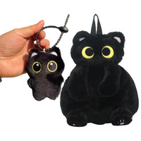 Thumbnail for A hand holds a small plush keychain beside KittyNook Cat Co.'s Cute Big Eyes Plush Backpack shaped like a black cat.