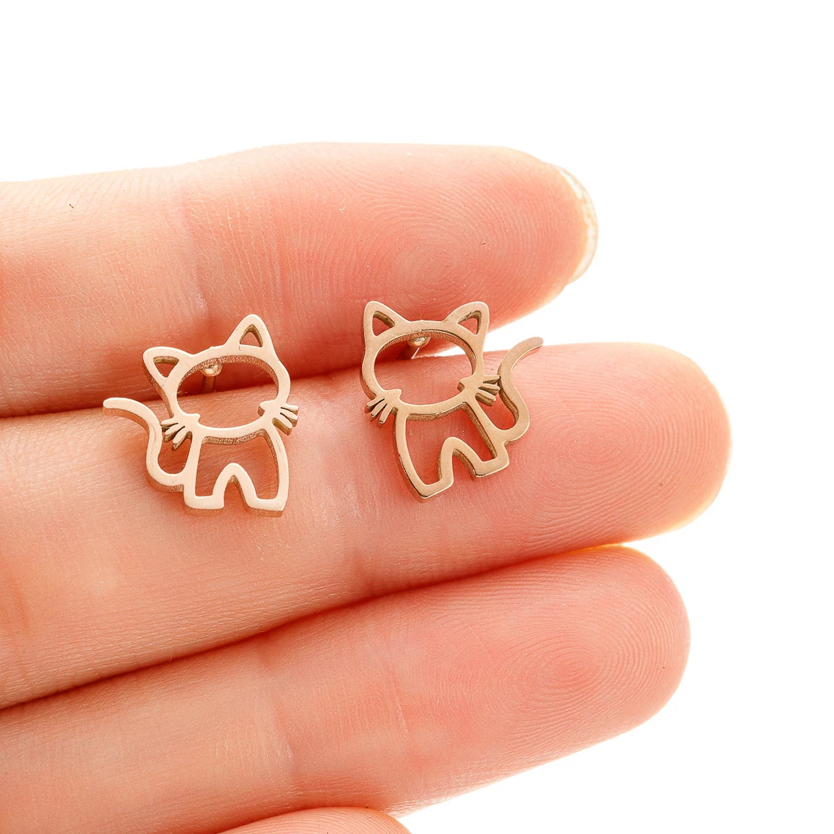 KittyNook Cat Co.'s KittyShine Stainless Steel Ear Studs are shown on fingertips against a white background.