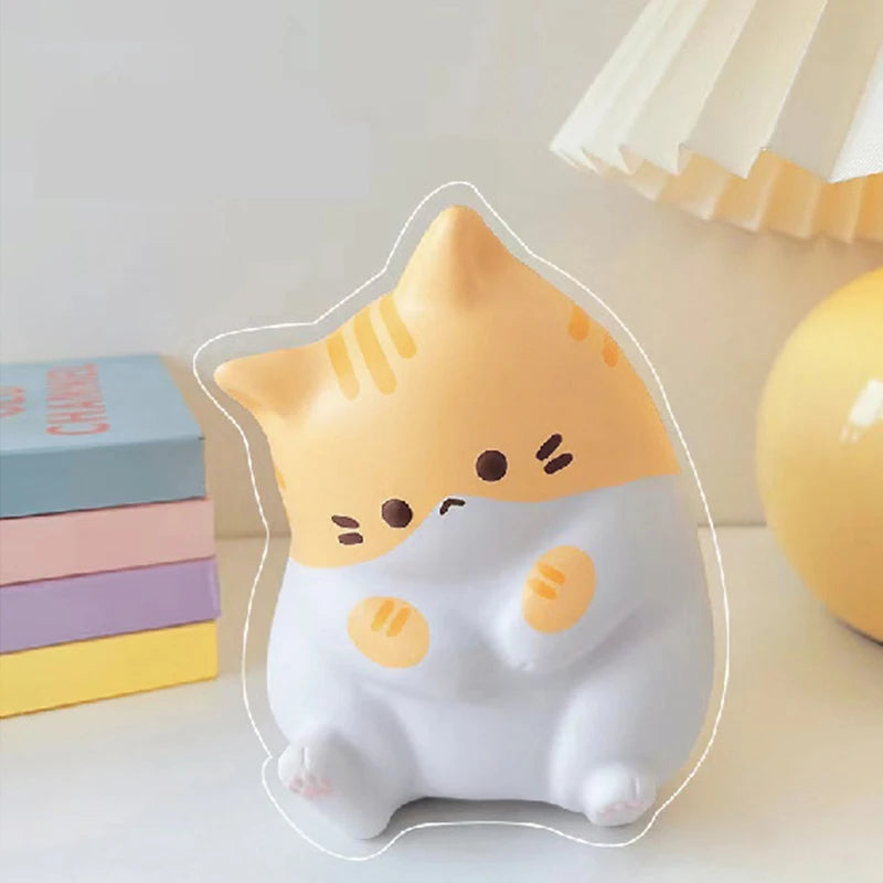 The KittyNook Cat Co. Cat Squeeze Ball is a cute yellow and white squishy toy, perfect for your desk.