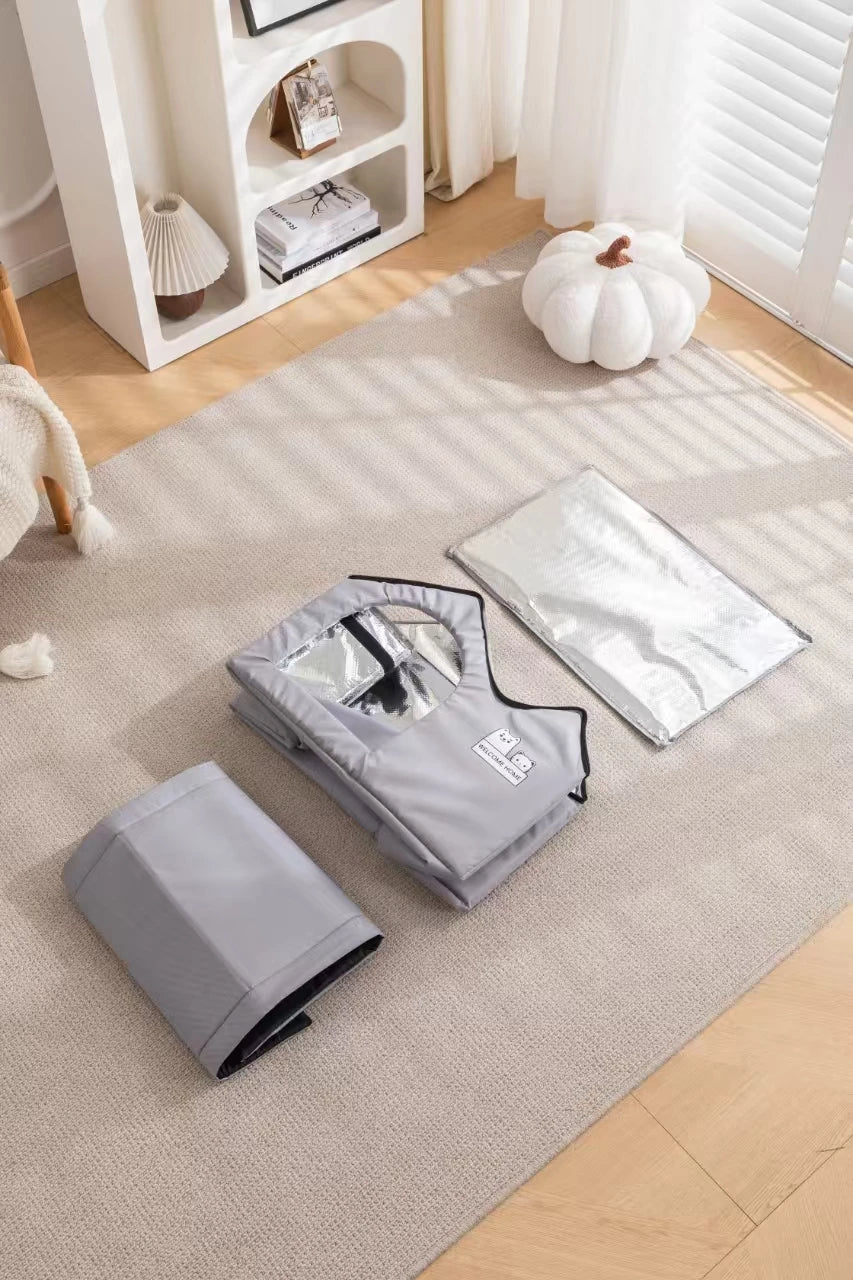 Folded and open gray KittyNook Cat Co. Portable Pet Cooling Houses with silver liners rest on a beige carpet in a bright room.