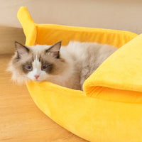 Thumbnail for A fluffy cat lounges in the KittyNook Cat Co. Cute Funny Banana Shape Cat Bed with orthopedic support.