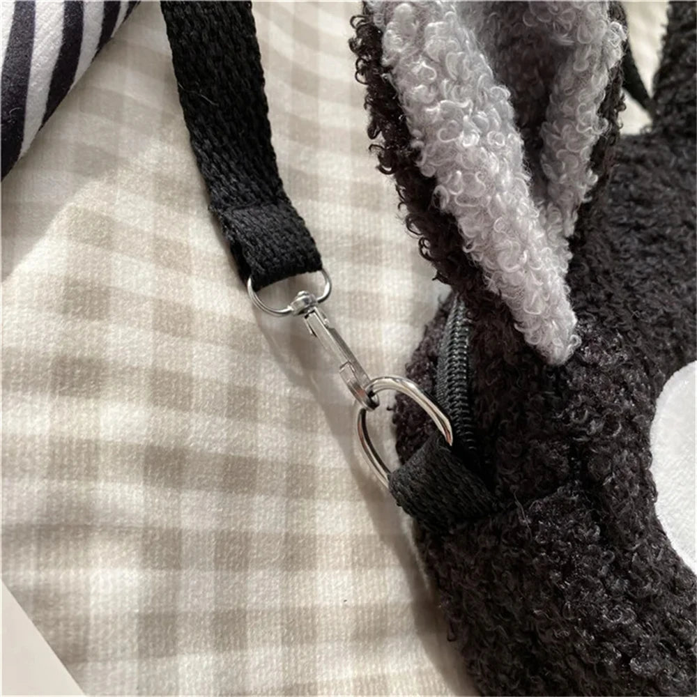 Close-up of a metal clasp securing the black strap to a fuzzy gray KittyNook Cat Co. Neko Soft Cat Shoulder Bag.