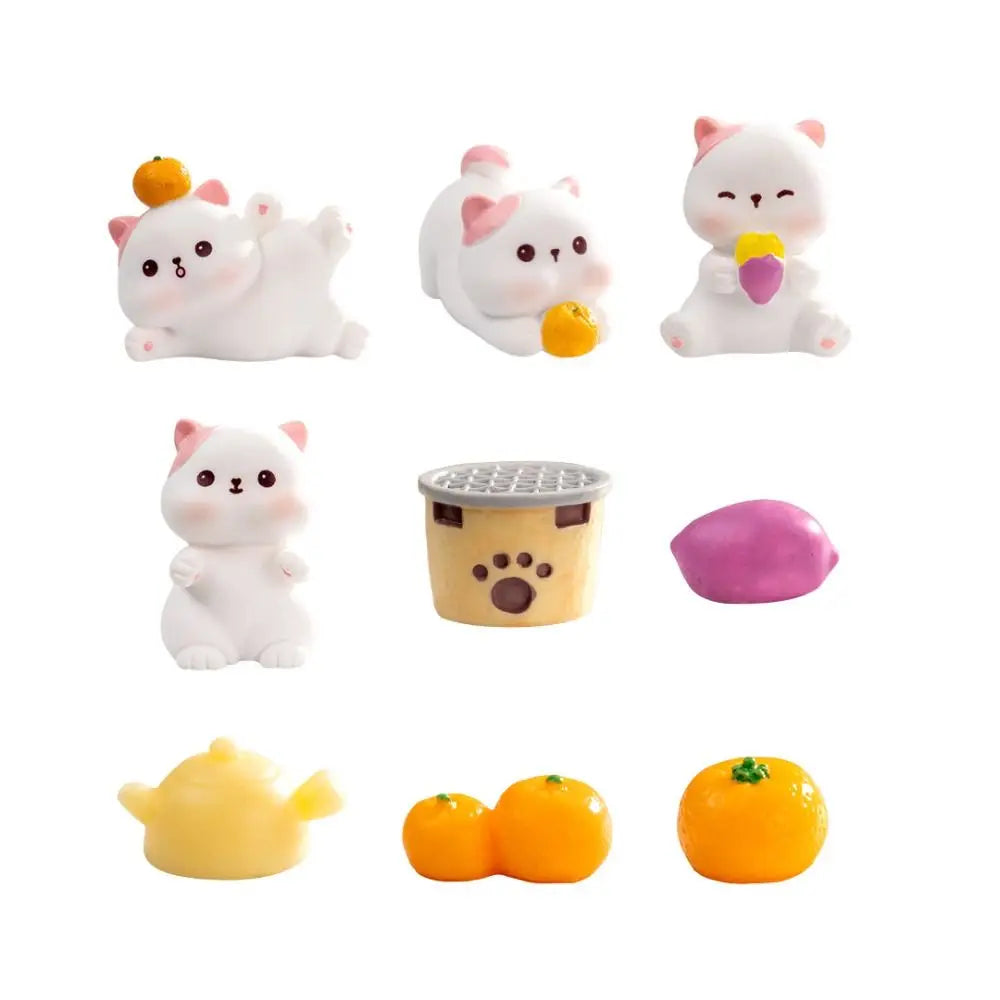 Nine small toys, like KittyNook Cat Co. Creative Cat Doll Car Ornament, a grill, teapot, and fruits on white background.