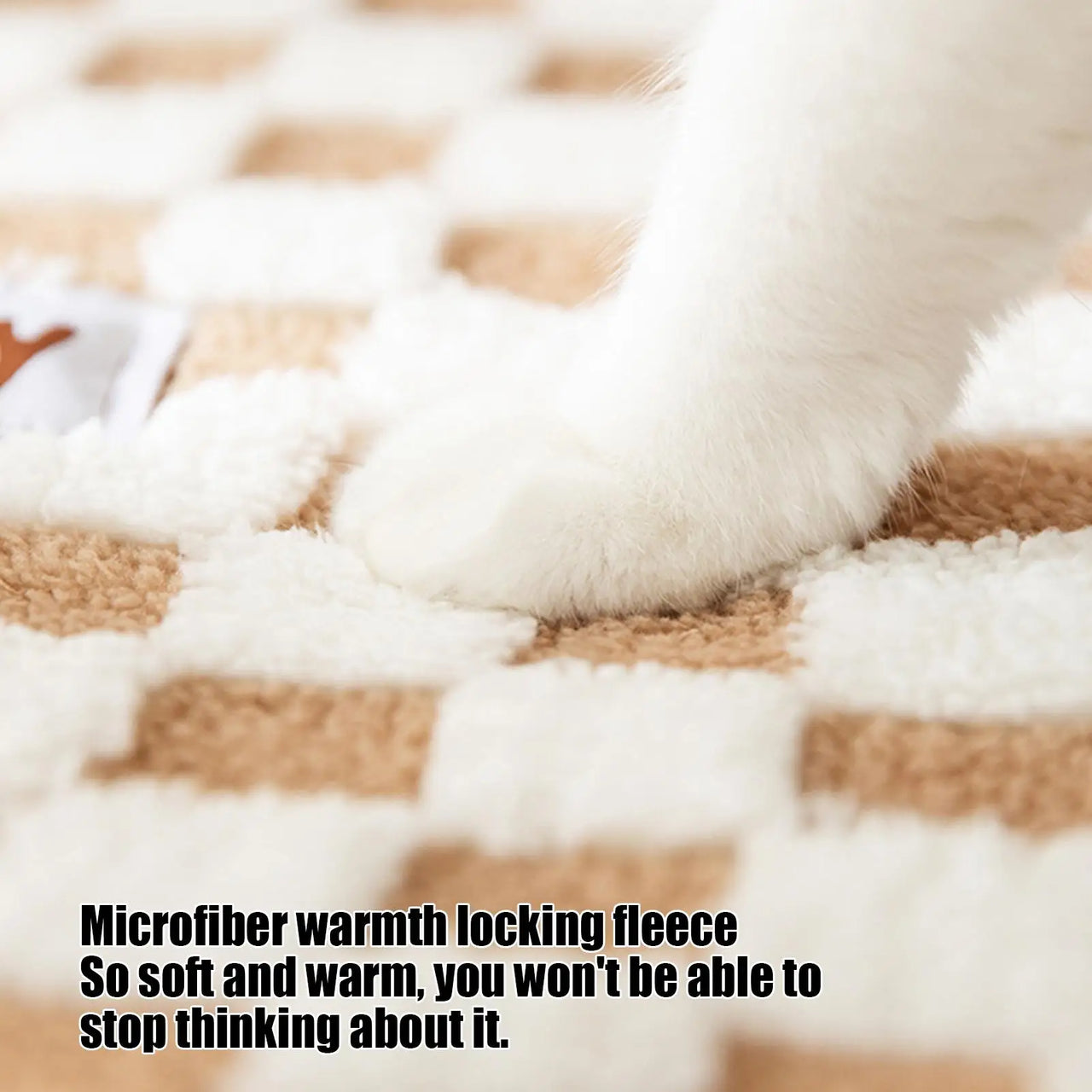 A white cat’s paw rests on fleece, cozy beside the KittyNook Cat Co. Winter Warm Plush Tunnel Cat Bed.