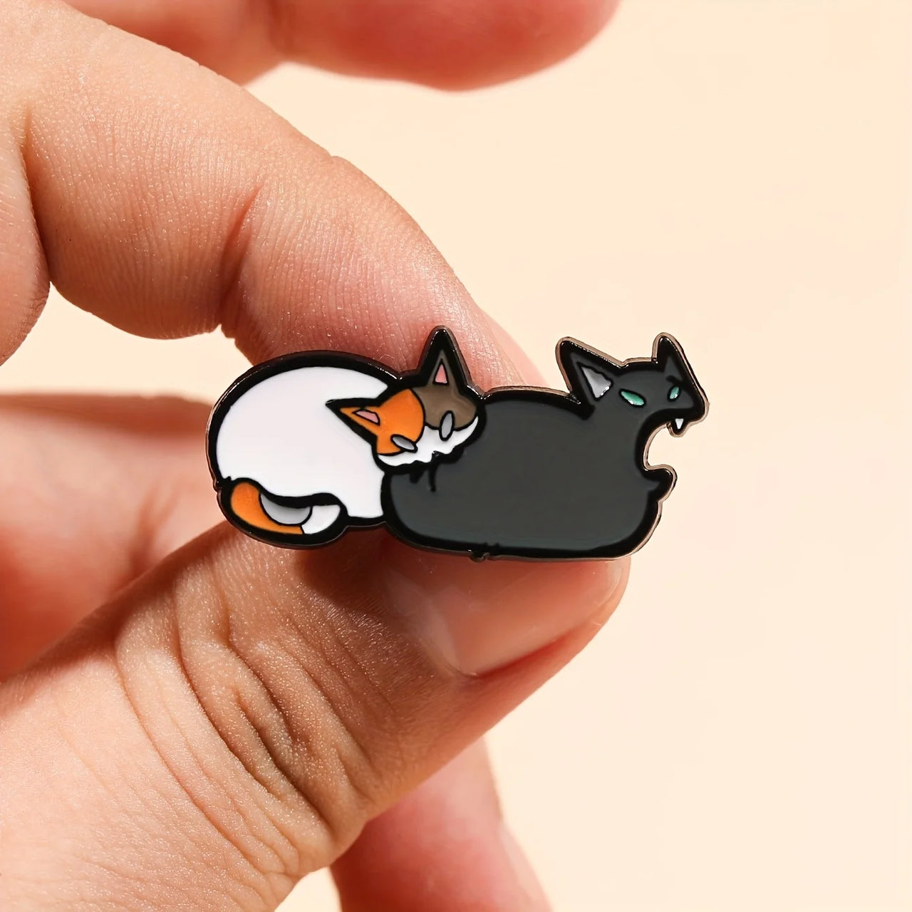 A hand holds the Cute Feline Enamel Brooch by KittyNook Cat Co.—a perfect fashion pin for any cat lover.