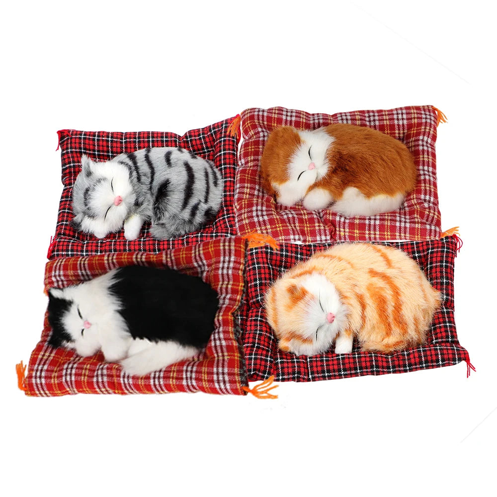 KittyNook Cat Co.’s Sleepy Kitten Plush Decoration naps on plaid cushions—adorable for home or car décor.