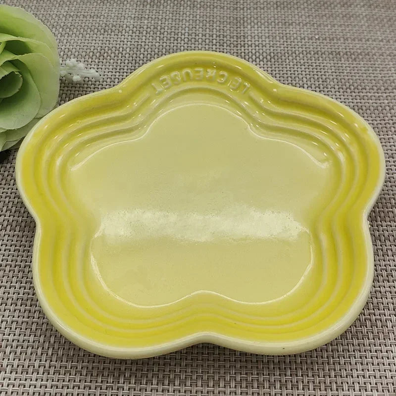 KittyNook Cat Co. Extra Wide Raised Flower Cat Bowl, yellow, on woven placemat with green artificial flower left.