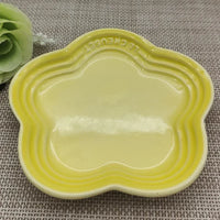Thumbnail for KittyNook Cat Co. Extra Wide Raised Flower Cat Bowl, yellow, on woven placemat with green artificial flower left.
