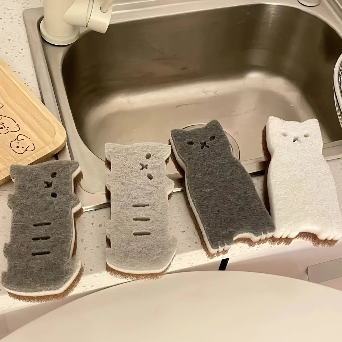 KittyNook Cat Co.’s Adorable Cat-Shaped Dish Sponge Set – 4 pieces, in gray and white, sits by the kitchen sink.