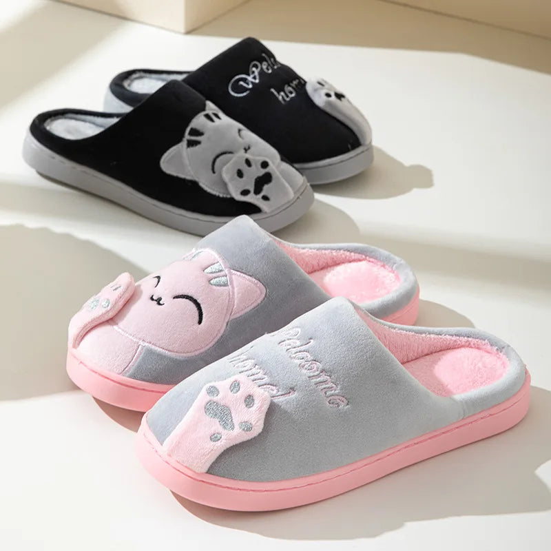 Two pairs of KittyNook Cat Co. Happy Pawprints Lucky Cat Slippers in gray-pink and black-white with paw prints.