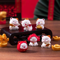 Thumbnail for Six KittyNook Cat Co. Chinese Cartoon Fortune Cat Ornaments with gold accents make a meaningful gift on a wooden stand.
