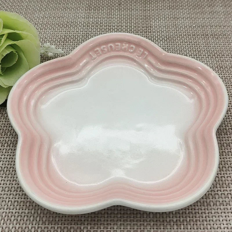 KittyNook Cat Co. Extra Wide Raised Flower Cat Bowl in pink and white on woven surface with a green faux flower nearby.