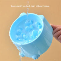 Thumbnail for A hand rinses the blue KittyNook Cat Co. Elevated Anti-Choke Slow Feeder Bowl under running water with text above.