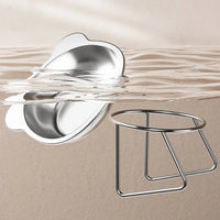 Thumbnail for KittyNook Cat Co.'s Ergonomic Tilted Stainless Steel Cat Bowl and stand sit partly in clear water on a beige background.
