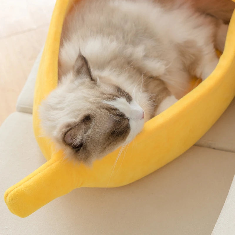 A fluffy cat lounges in the KittyNook Cat Co. Cute Funny Banana Shape Cat Bed, enjoying cozy orthopedic support.