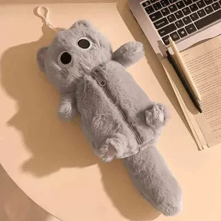 The Kawaii Big-Eyed Cat Plush Pencil Case by KittyNook Cat Co. sits on a desk beside a laptop, notebook, and pen.
