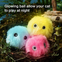 Thumbnail for Three glowing, fluffy balls with eyes sit in a nest—KittyNook Cat Co.’s Interactive Cat Smart Ball Toy for enrichment.