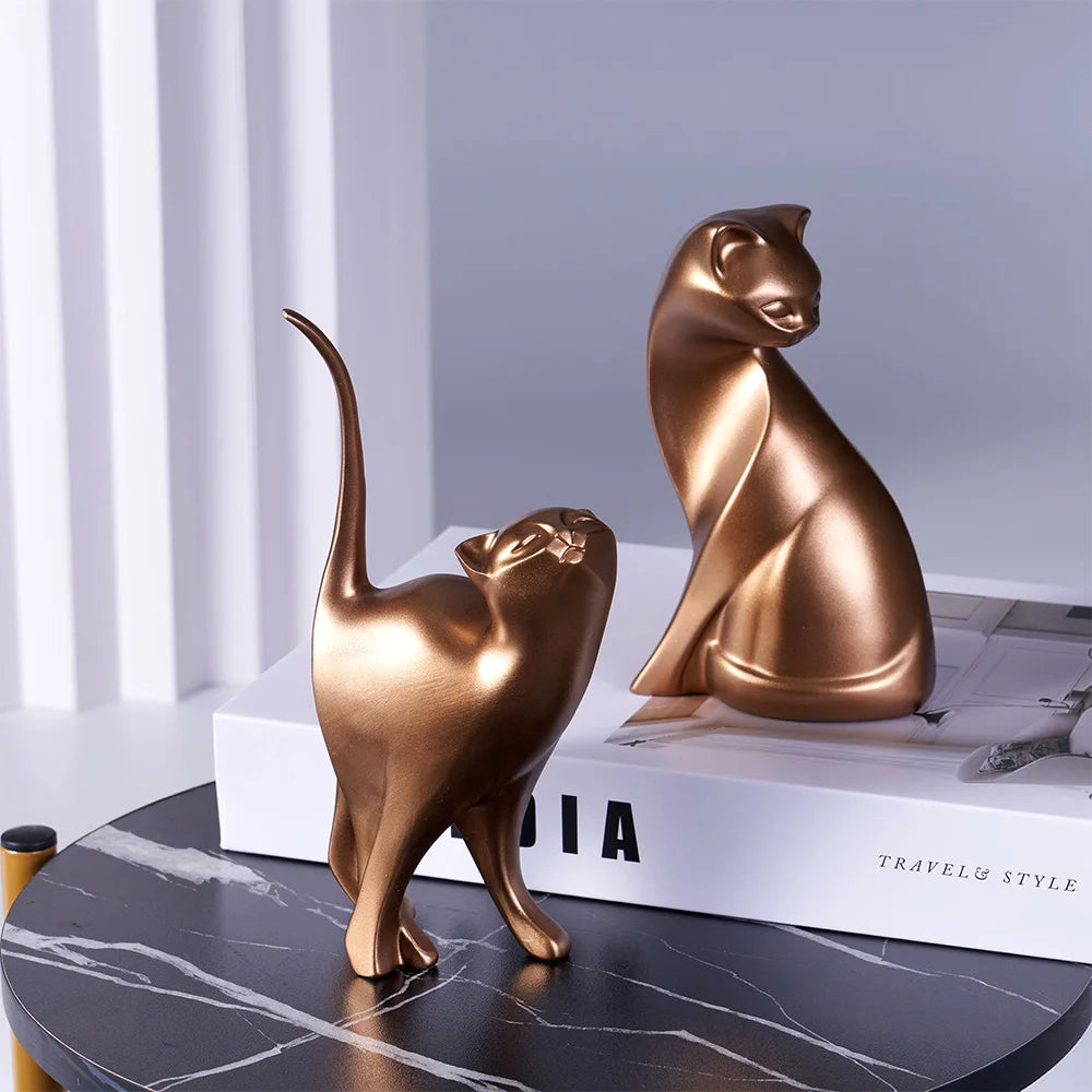 KittyNook Cat Co.'s Golden Couples Cat Figurine, ideal as couples decor or a gift, displayed on a table and book.