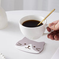 Thumbnail for Hand holding coffee with a gold spoon on KittyNook Cat Co.'s Cat Silicone Cup Coaster Mat, heat-resistant and non-slip.