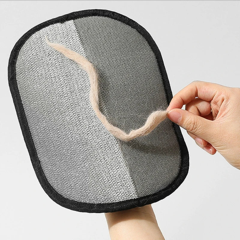 A hand cleans pet hair from KittyNook Cat Co. Pet Hair Removal Mitts, perfect for furniture, bedding & car seats.
